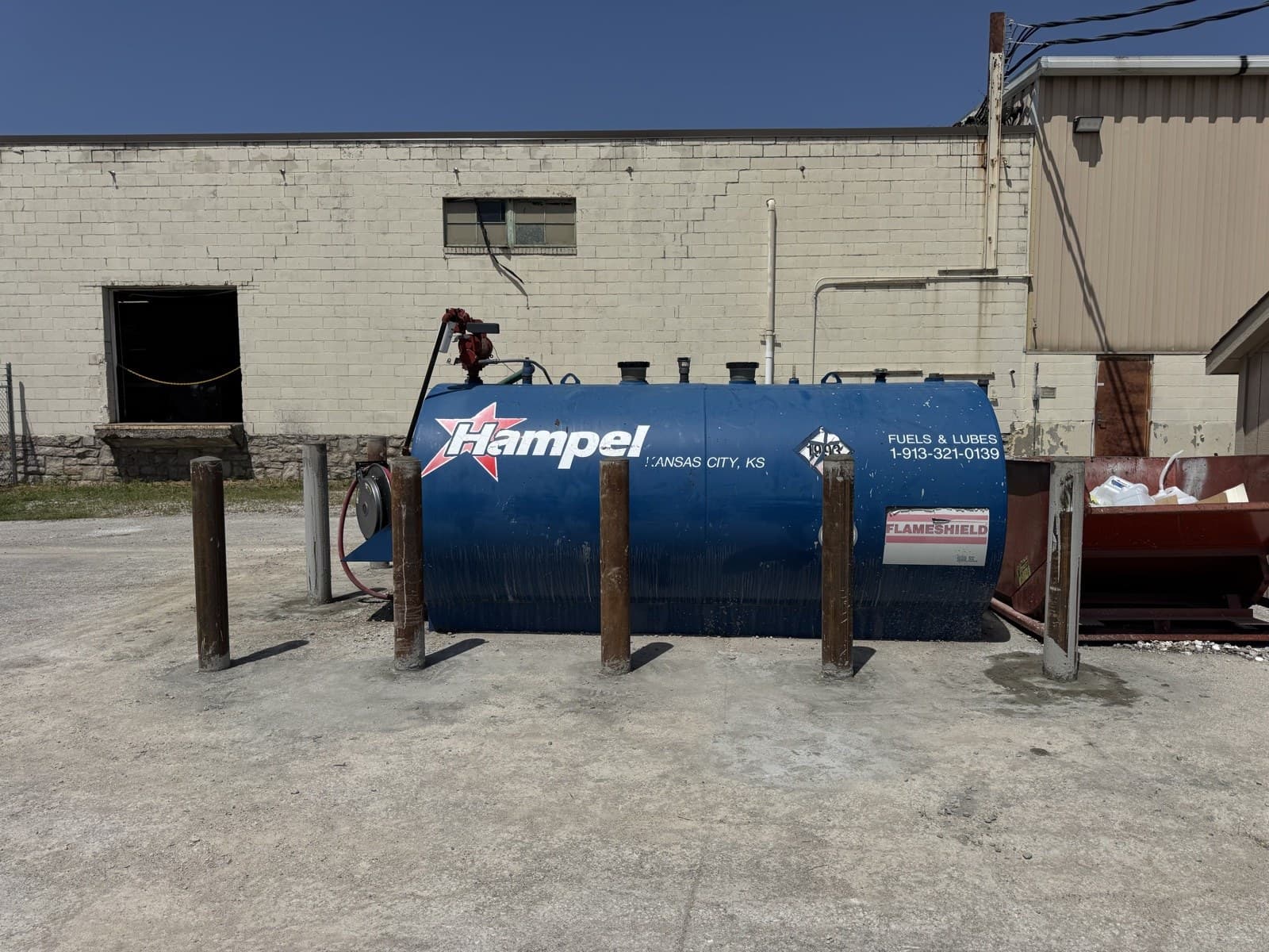 Row of steel bollards installed in front of a fuel tank