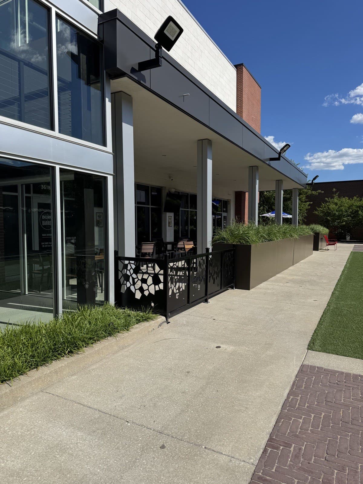 Custom ornamental cut-metal patio railing at a commercial storefront