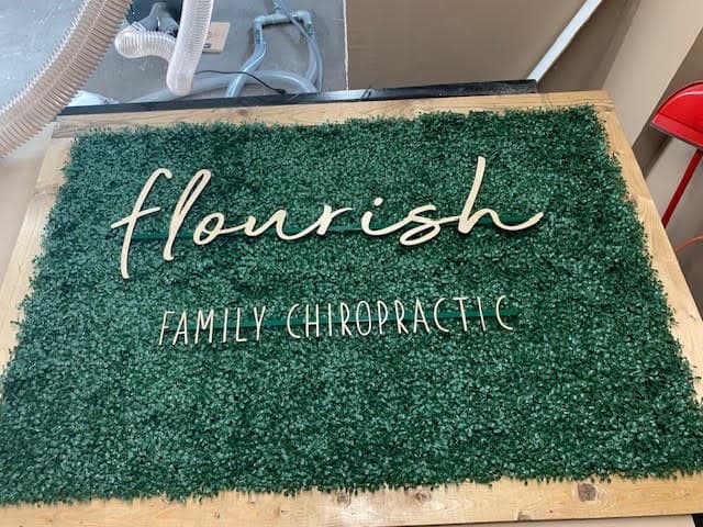 Custom 'Flourish Family Chiropractic' greenery business sign